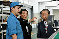 工場にて(若手社員の説明を聞く島社長と仁坂知事)