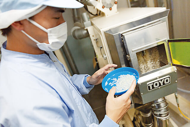 熟練オペレーターによる目視チェックの精米作業