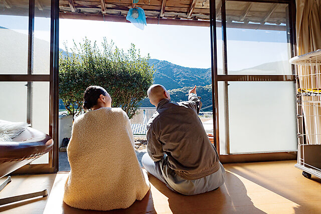 縁側から見える山を指差し仲睦まじく話すご夫妻