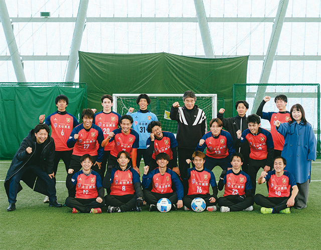 屋内練習場に集合しガッツポーズをとる南紀オレンジサンライズFCのメンバー