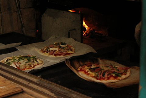 窯で焼いているピザの写真