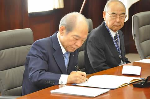 近畿大学　塩﨑　均　学長が協定書に署名の写真