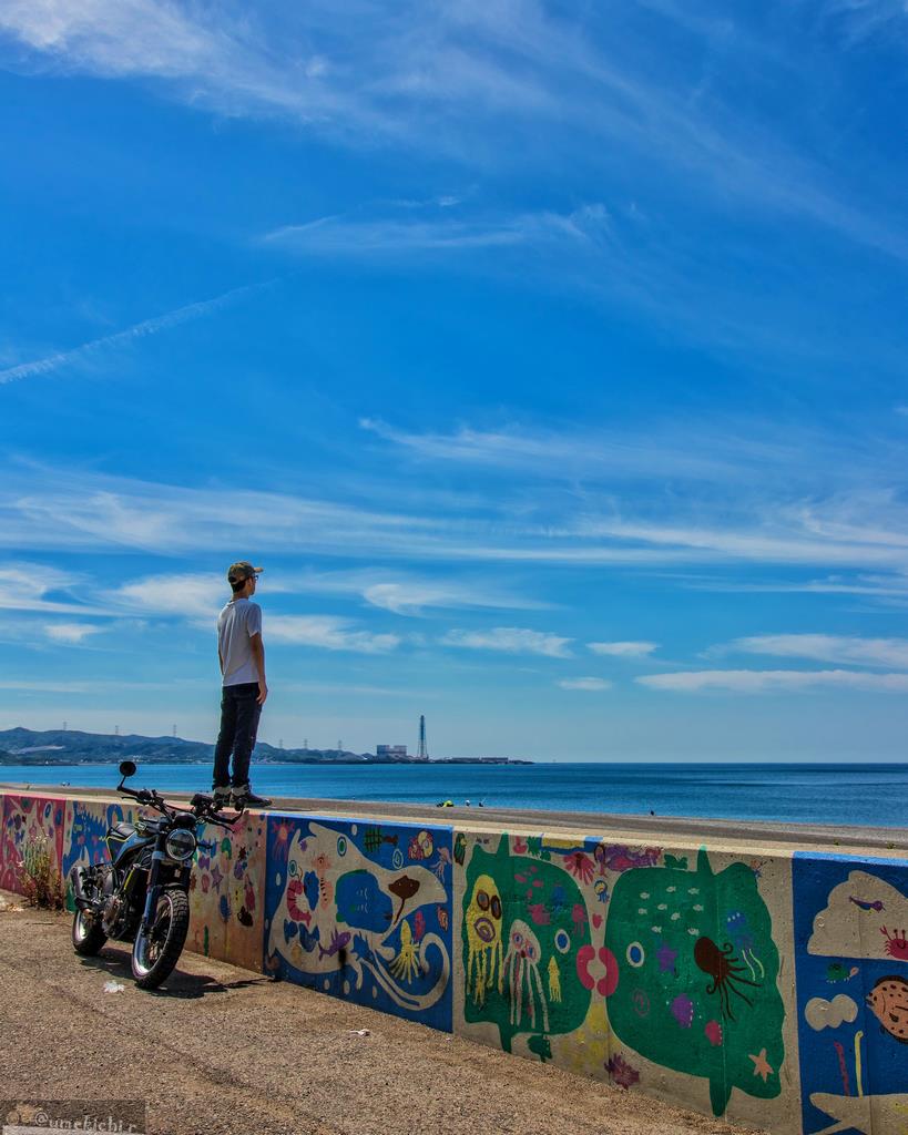煙樹ヶ浜とバイクと人の画像