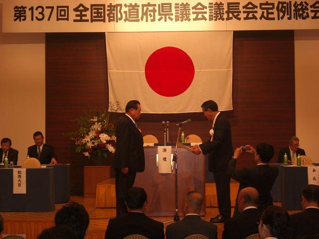 金子全国議長会会長から表彰を受ける門三佐博議員(左)の画像
